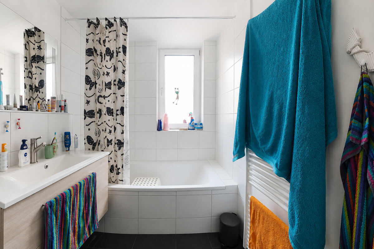 Badezimmer vor dem Umbau mit Eckbadewanne und Duschvorhang