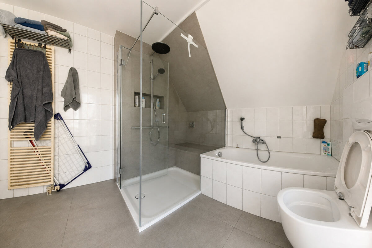 Bodenebene Dusche nach dem Umbau mit Glasabtrennung und Sitzbank