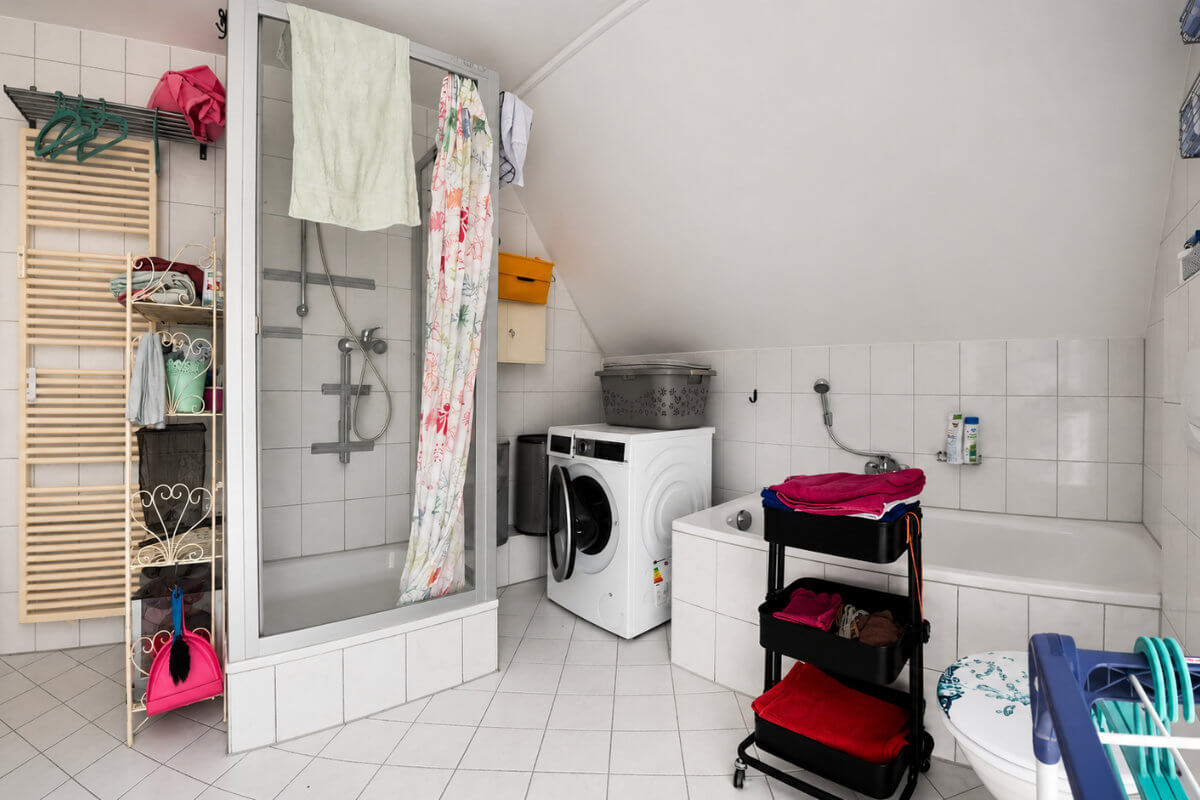 Badezimmer vor der Sanierung mit alter Duschkabine und hohem Einstieg